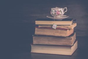 Ancient Urdu books with a traditional tea cup